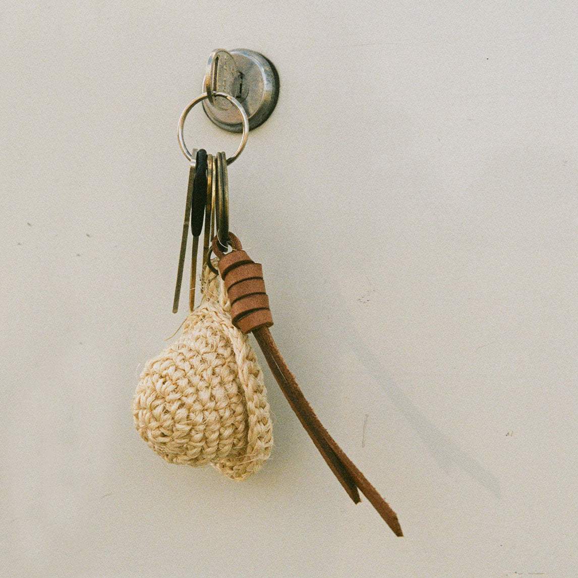 Keychain with woven heart and leather strap on a white background